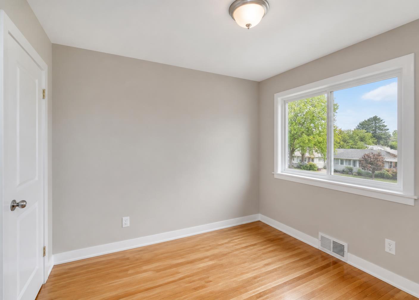 Bedroom after repaint: smooth greige walls with crisp white trim